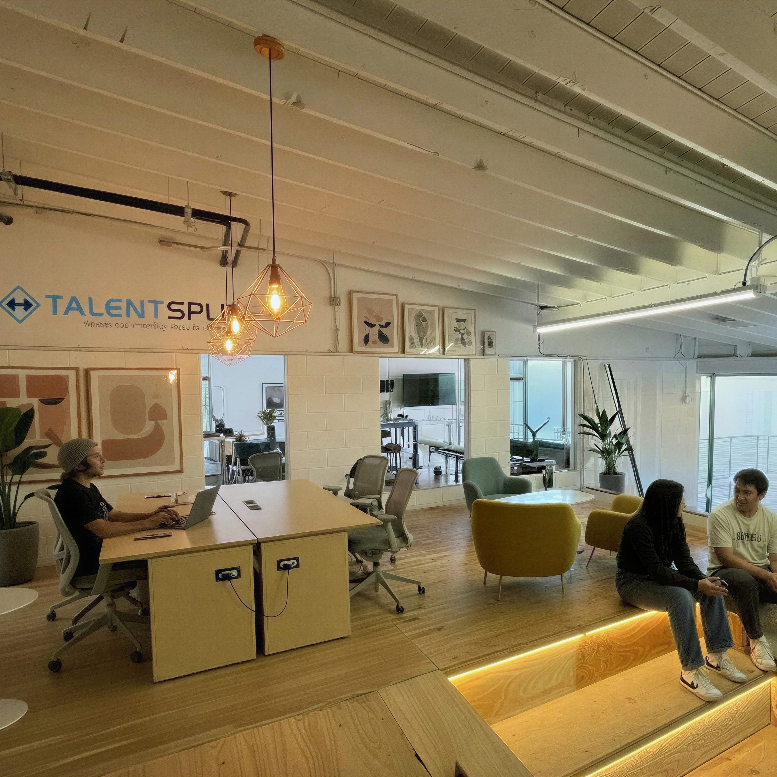 Interior of a modern coworking space with a small team in conversation around a table in warm afternoon light
